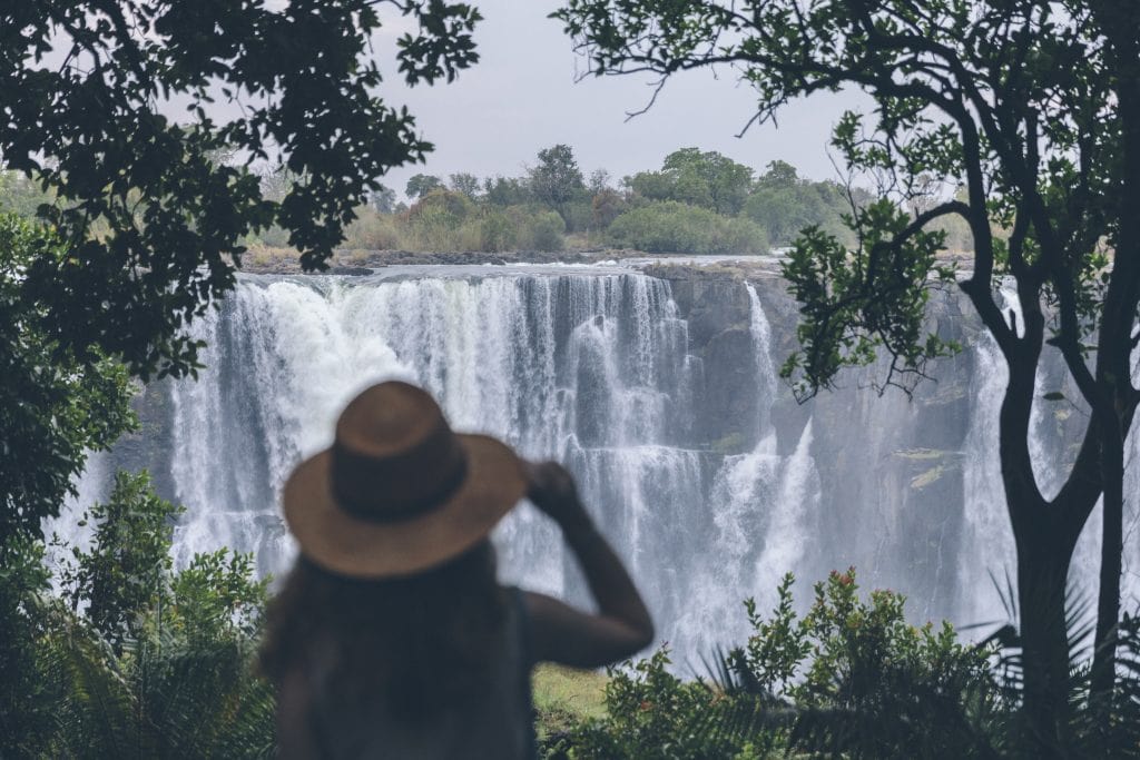 A Matetsi Victoria Falls guest looking at Victoria Falls through binoculars